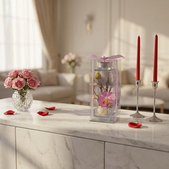 Aranjament floral cu orhidee roz în suport de sticlă cu lumânare