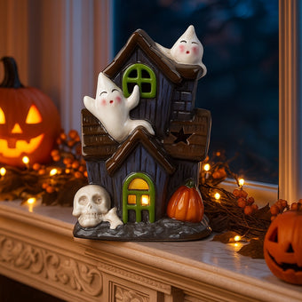 Decorațiune de Halloween în formă de casă bântuită cu fantome și lumină led, așezată pe un pervaz de marmură, decorat de Halloween