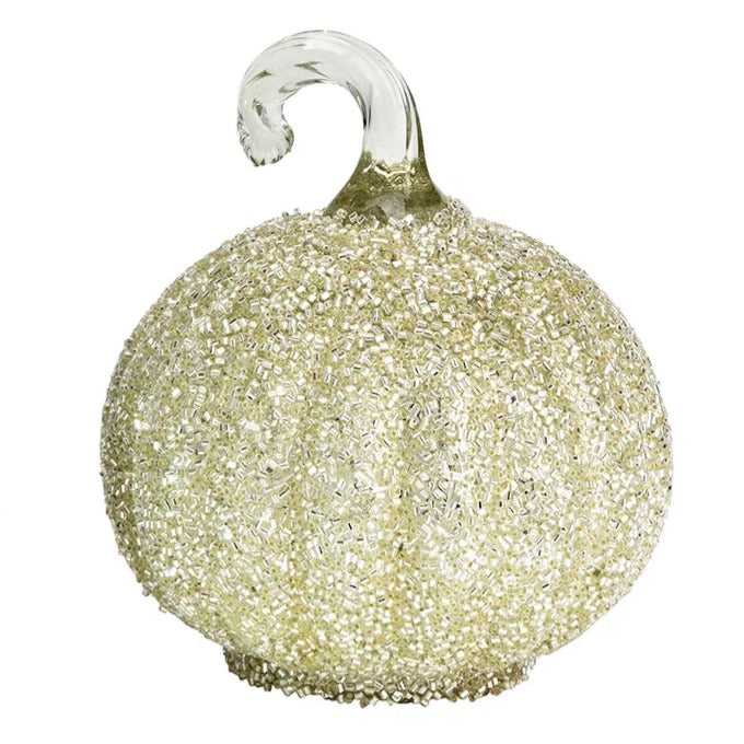 Dovleac decorativ din sticlă, de culoare albă și acoperit cu paiete