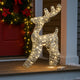 Figurină 3D în formă de ren cu lumini LED așezată in fața unei uși de intrare decorate de Crăciun