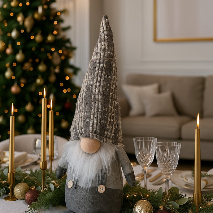 Gnom decorativ de Crăciun cu pălărie lungă gri așezat pe o masă festivă decorată de Crăciun