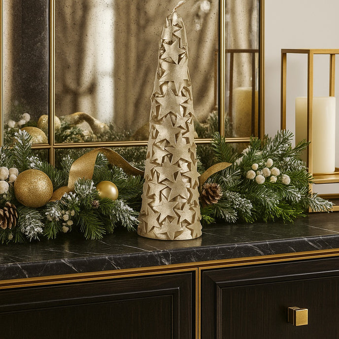 Lumânare în formă de brad auriu cu stele și sclipici așezată pe un bufet cu blat de marmură neagră, decorat de Crăciun