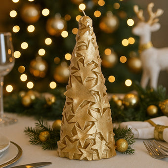 Lumânare în formă de brad auriu cu stele și sclipici așezată pe o masă festivă împodobită de Crăciun