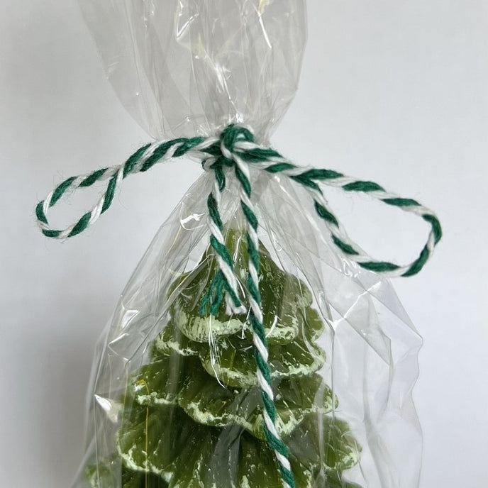Lumânare în formă de brad verde Crăciun ambalată in folie de plastic și legată cu o ață verde cu alb