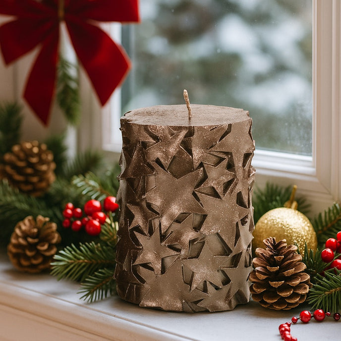 Lumânare cilindrică decorativă cu stele și sclipici Crăciun așezată pe un pervaz decorat de Crăciun