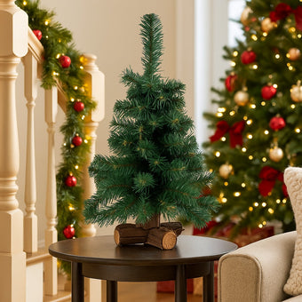 Mini brad artificial decorativ de Crăciun așezat pe o masa lânga o sofa, într-un living decorat de Crăciun