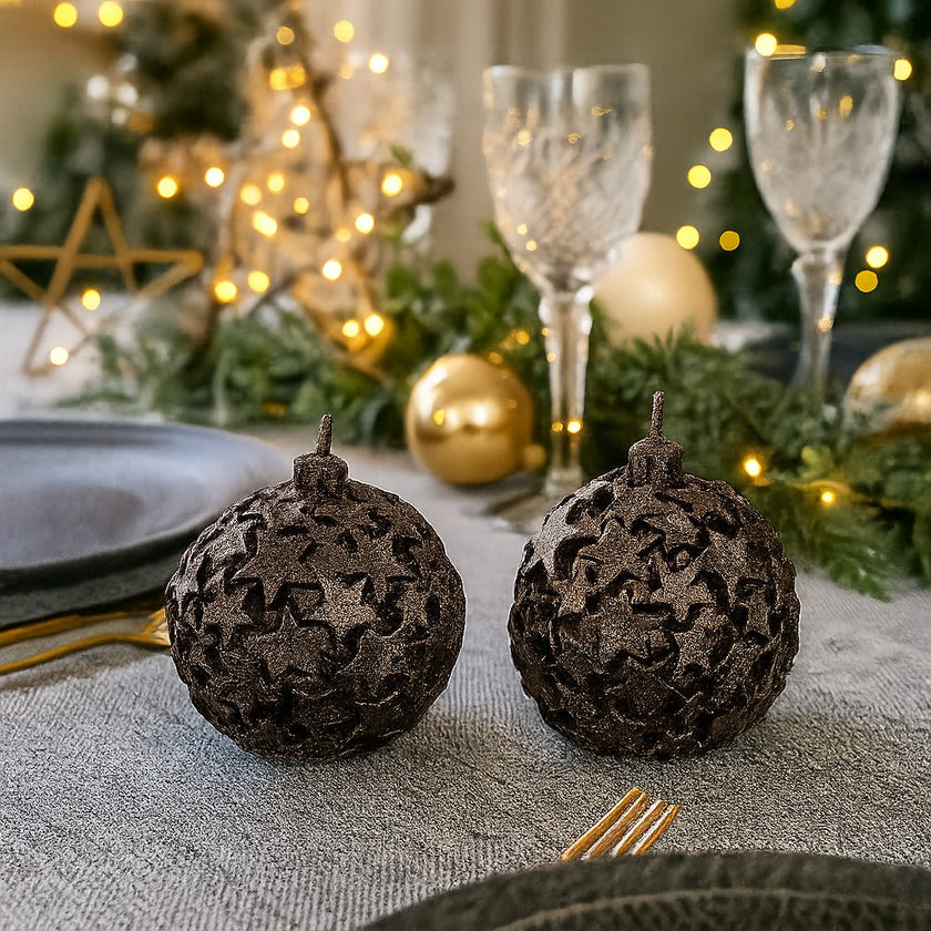 Set 2 lumânări glob, maro cu stele de Crăciun așezate pe o masă festivă decorată de Crăciun
