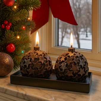Set 2 lumânări glob, maro cu stele de Crăciun așezate pe un pervaz de marmură decorat de Crăciun
