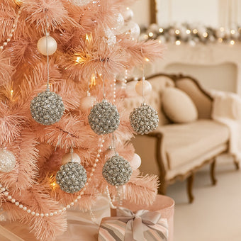 Set globuri argintii de Crăciun cu cristale, agățate pe un bard roz, decorat de Crăciun