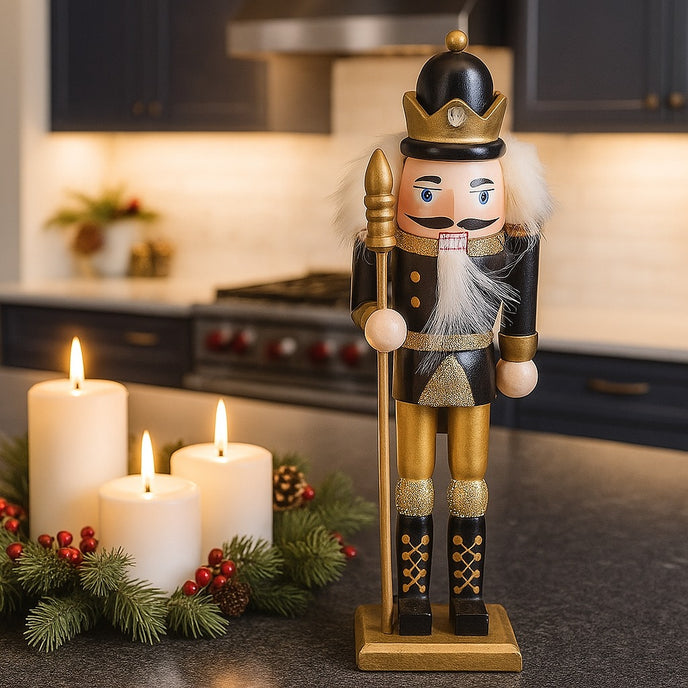 Spărgător de nuci cu coroană, negru cu auriu așezat pe un blat negru de bucătărie, lângă 3 lumânări ce ard