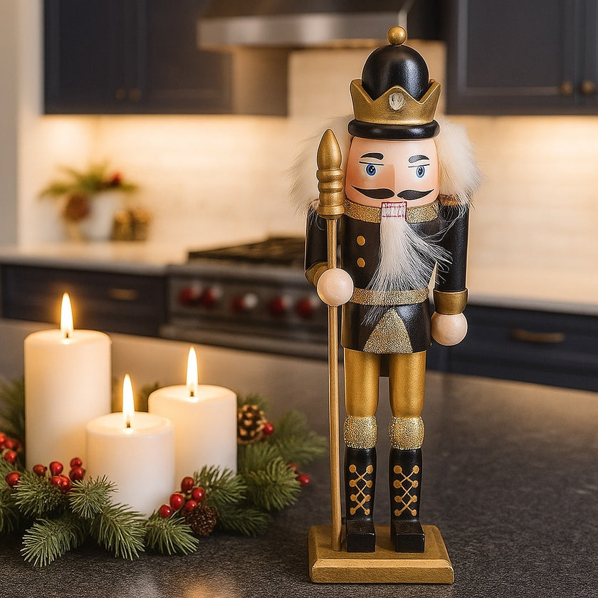 Spărgător de nuci cu coroană, negru cu auriu așezat pe un blat negru de bucătărie, lângă 3 lumânări ce ard