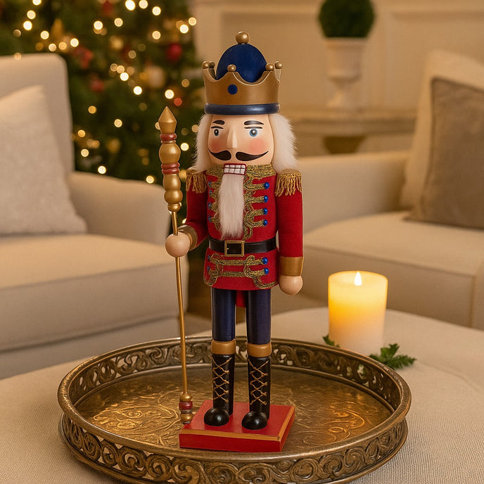 Spărgător de nuci decorativ regal cu coroană și sceptru așezat pe o tavă aurie lângo o lumânare