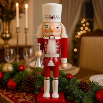 Spărgător de nuci cu trompetă alb și roșu așezat pe o masa festivă decorată de Crăciun
