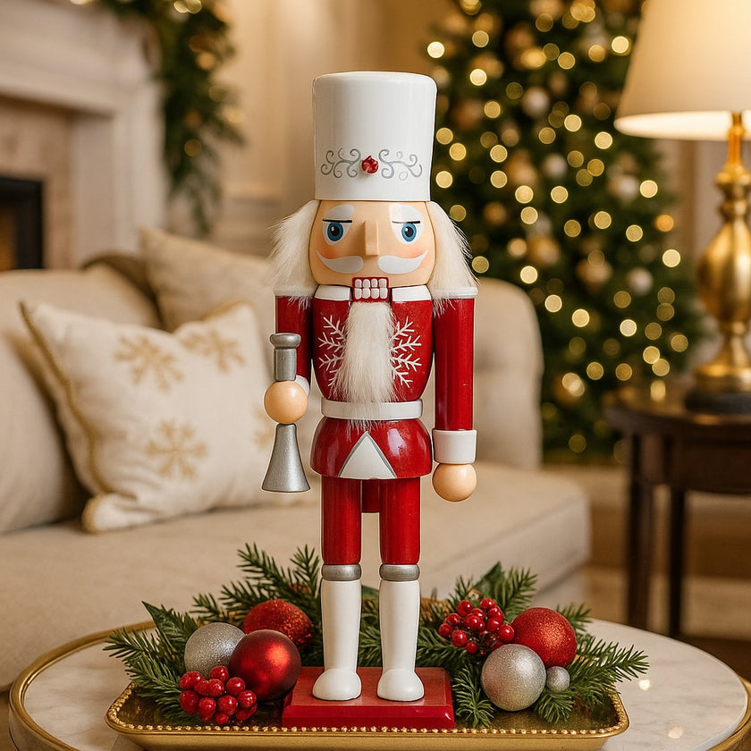 Spărgător de nuci cu trompetă alb și roșu așezat pe o tavă aurie decorată de Crăciun. Tava este așezată pe o masă rotundă cu blat de marmură