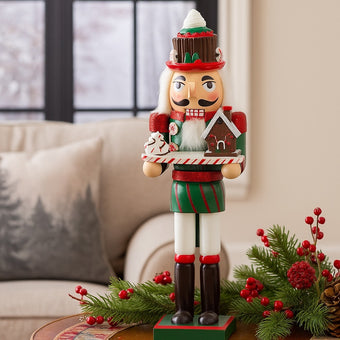 Spărgător de nuci decorativ cu căsuță de turtă dulce și frișcă așezat pe o masă decorată de Crăciun