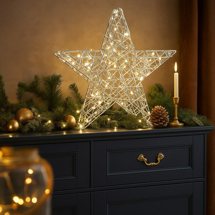 Stea decorativă argintie cu leduri aprinse, așezată pe un bufet de lemn albastru, decorat de Crăciun