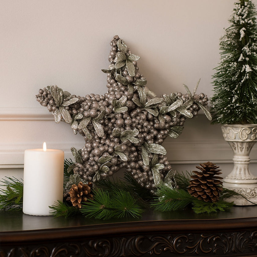 Stea decorativă de Crăciun cu bobițe argintii și frunze verzi așezată p eun bufet din lemn, decorat de Crăciun