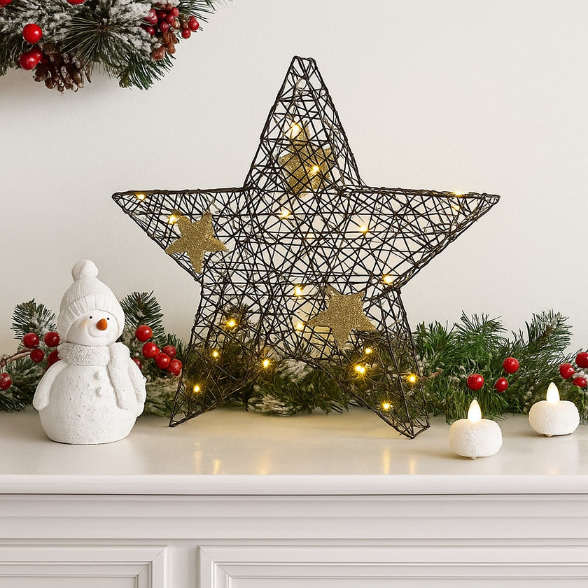 Stea decorativă neagră cu leduri aprinse, așezată pe un bufet de lemn alb, decorat de Crăciun cu ghirlande