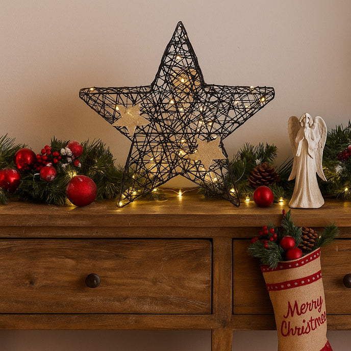 Stea decorativă neagră cu leduri aprinse, așezată pe un bufet de lemn, decorat de Crăciun