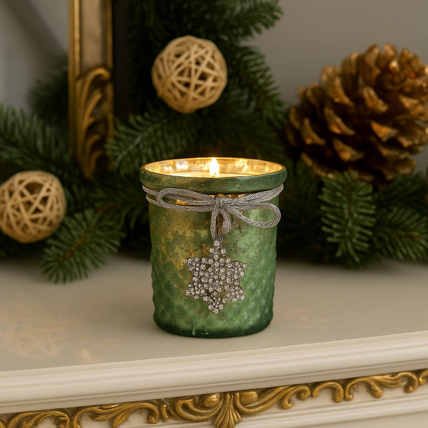 Suport de lumânare din sticlă verde, aprins, așezat pe mantaua șemineului, decorată de Crăciun 